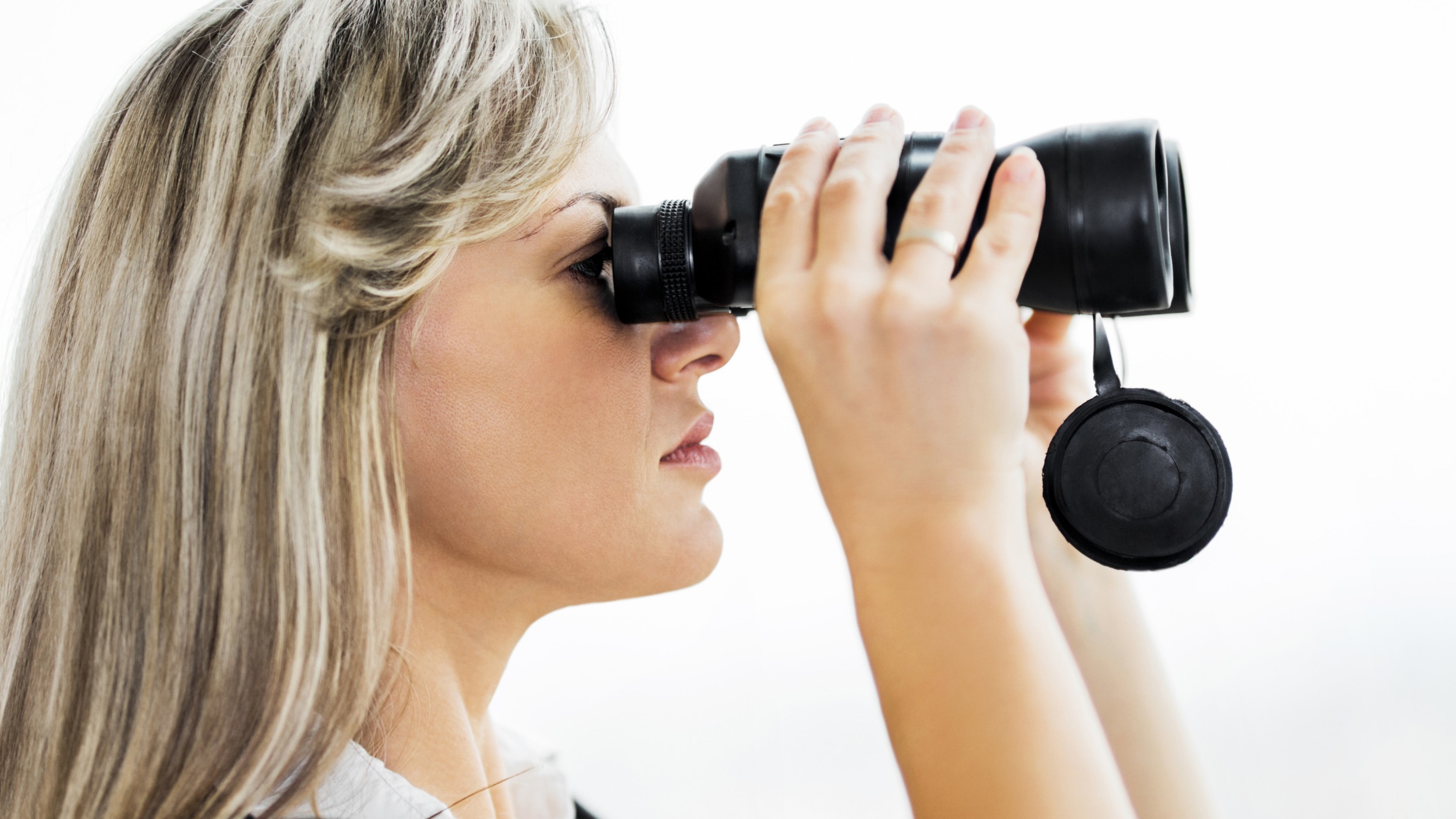 Woman looking through binoculars, illustrating predictions for the year ahead