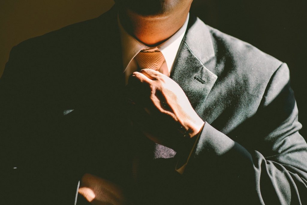 Manager adjusting his tie, illustrating leaders who engage with their teams