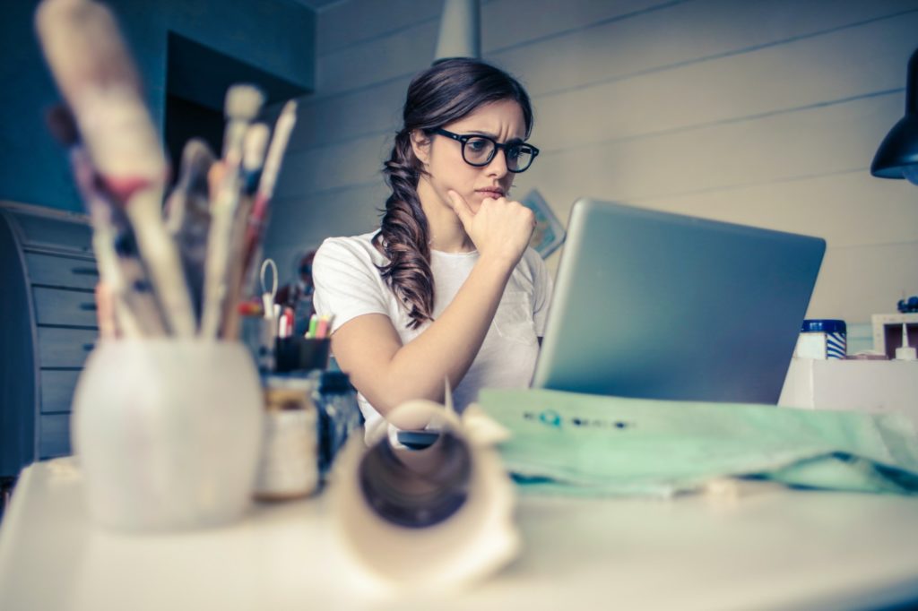Employee looking dissatisfied at her laptop, illustrating the drivers of the great resignation