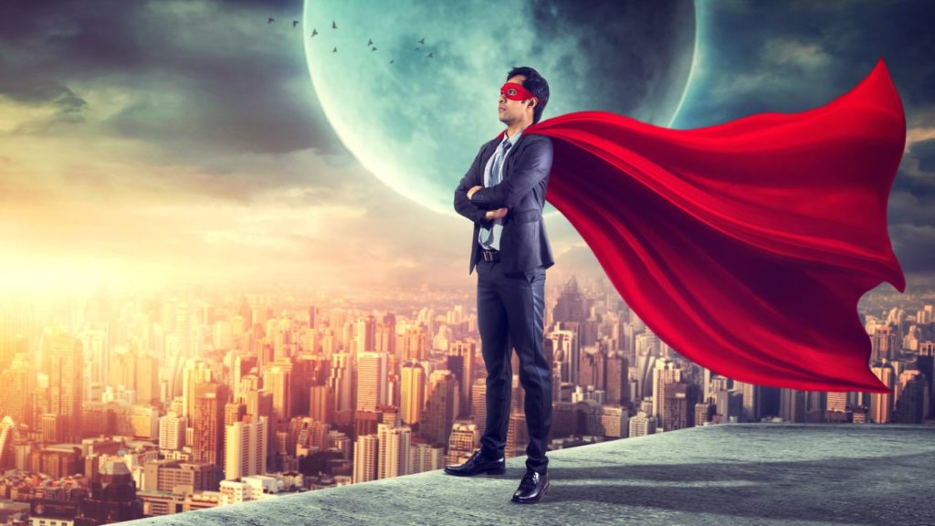 Businessman in a superhero cape above a city skyline, illustrating leading with mission and values
