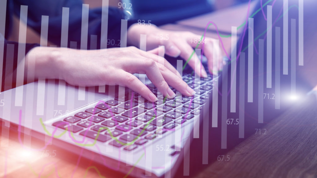 Hands typing on a laptop overlaid with charts, illustrating digital HR becoming the norm