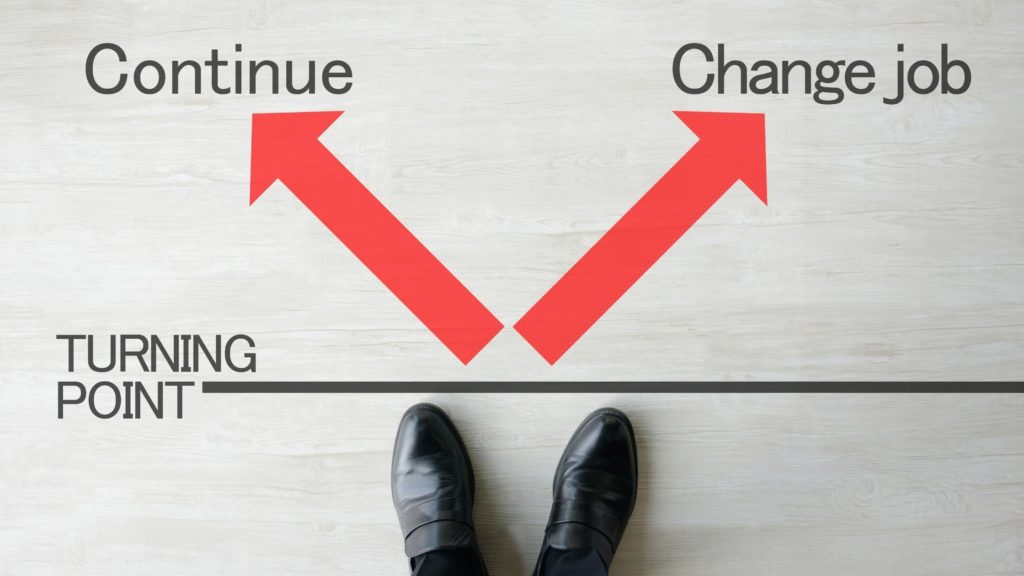 Feet at a turning point between arrows marked continue and change job, illustrating talent mobility