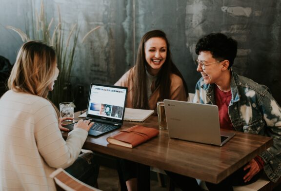 three people sat in meeting laughing