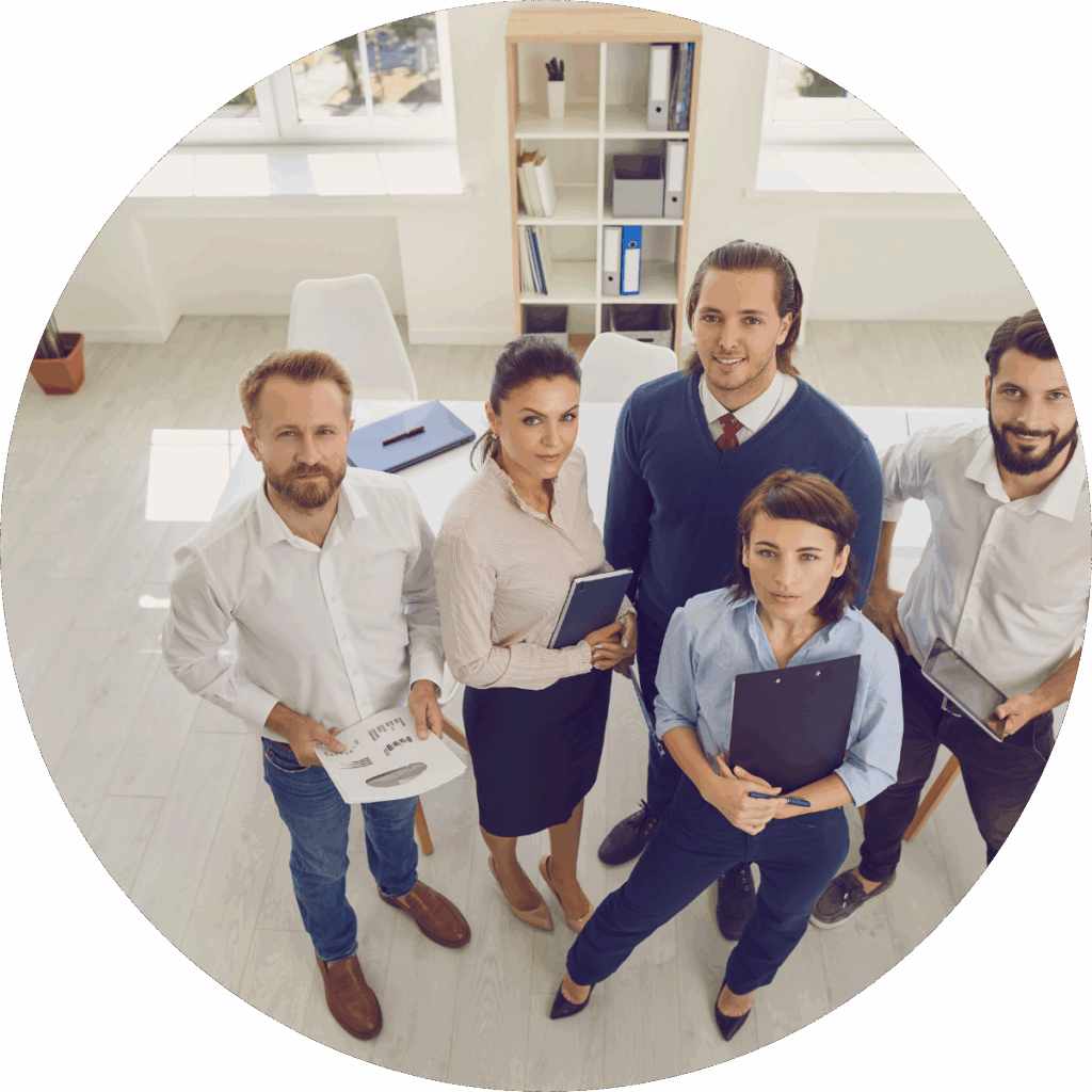 Team of five colleagues standing together in an office with notes and tablets