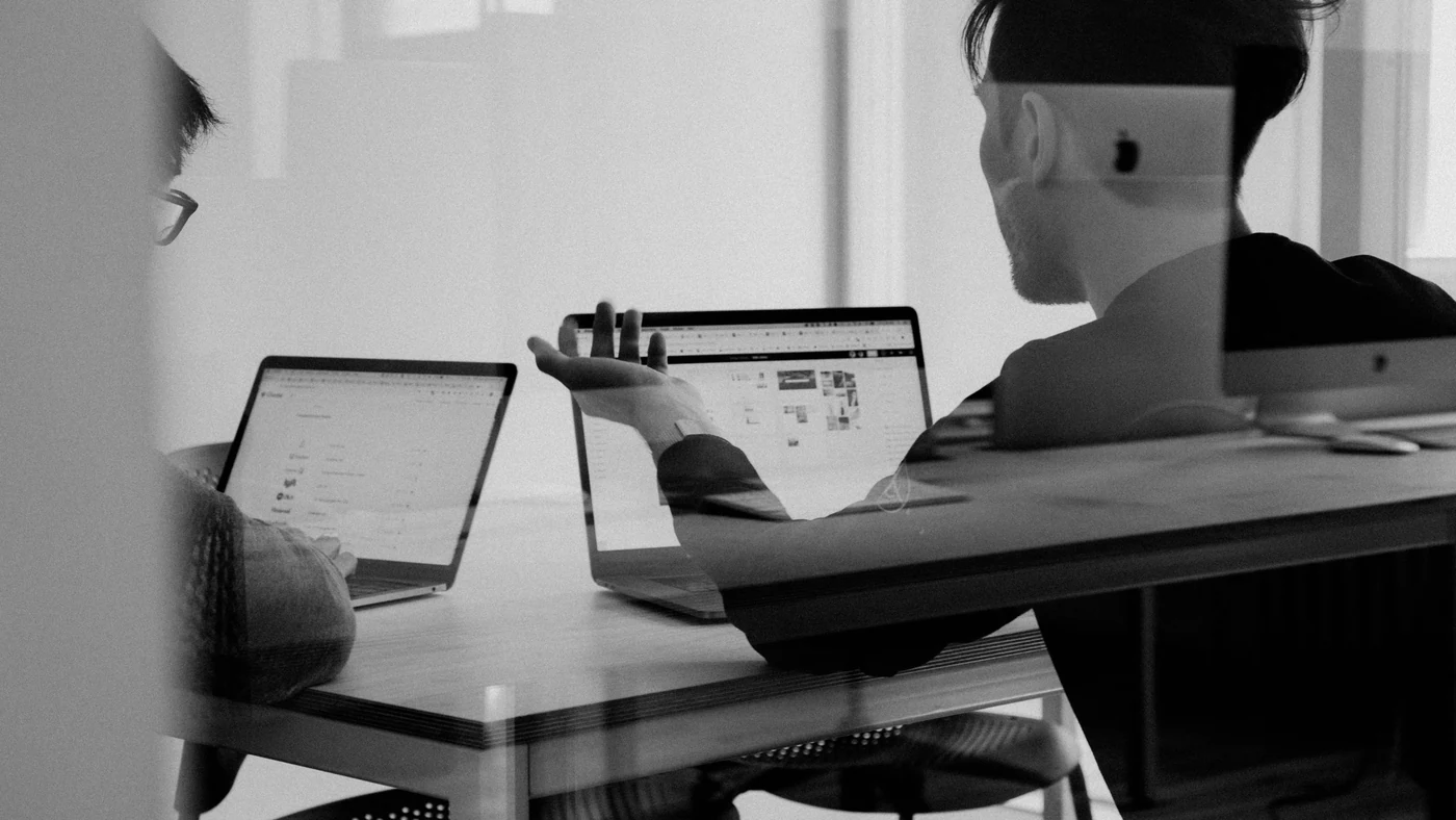 A manager and an employee sitting side by side going through appraisal notes together